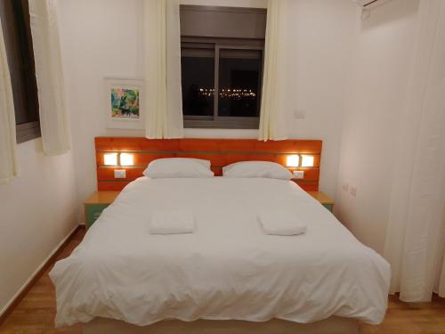 阿什杜德Beautiful beach apartment的卧室配有一张大白色床和窗户