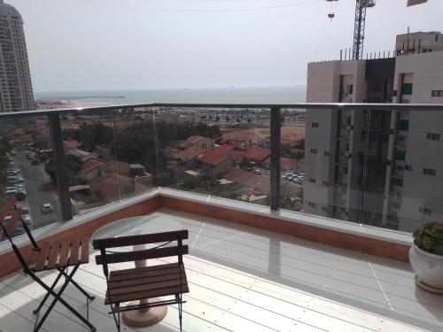 阿什杜德Beautiful beach apartment的阳台设有长凳,享有城市美景。