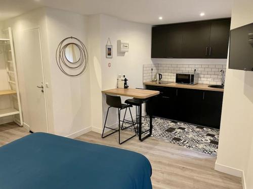 贝济耶Le Moulin 3 - Appartement Tout Confort Centre Ville - Beziers - Wifi - Tv connecté的一间带一张床的房间和一间带桌子的厨房