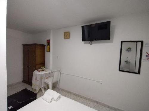 卡塔赫纳HABITACION CERCA DE LA UNIVERSIDAD DEL Sinu的一间设有桌子的房间和墙上的电视