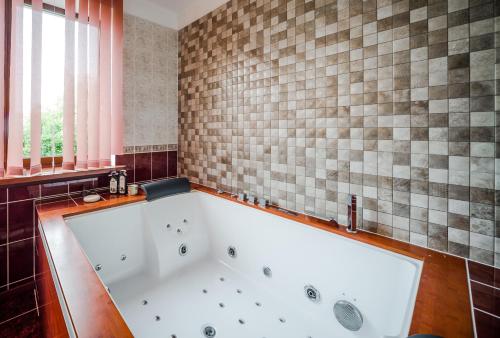 马鲁佩里加别墅的浴室设有大浴缸,铺着瓷砖