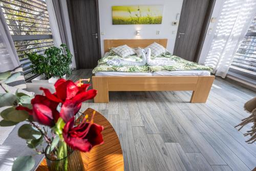 捷克布杰约维采阿特列尔兰那酒店的一间卧室配有一张床、一张桌子和鲜花