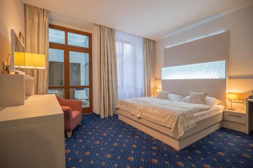 利托米什尔金星酒店的配有一张床和一把椅子的酒店客房