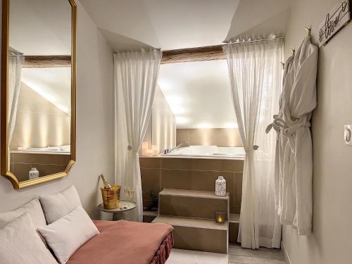 圣艾蒂安Cocon Blanc câlin - Jacuzzi privatif - Love Room à Saint Etienne的一间卧室配有床、水槽和镜子