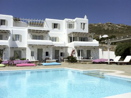 帕诺尔莫斯米科诺斯亚克索斯住处酒店的一座大型白色房子,前面设有一个游泳池