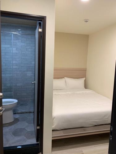 Ruifang晶晶輕旅民宿的一间卧室设有一张床和一个玻璃淋浴间