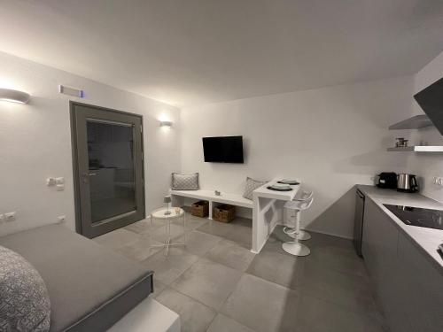 德里奥斯Alexander Suites的白色的小厨房配有书桌和电视