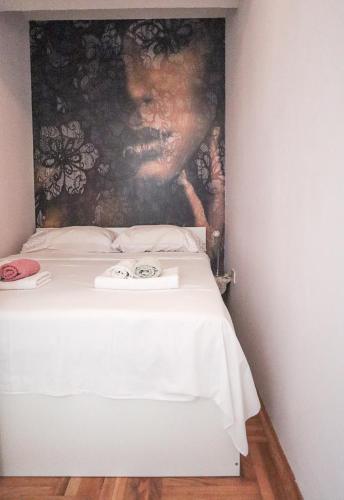 萨格勒布Josipa的一张白色的床,墙上挂着一幅画