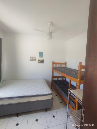 瓜拉图巴Casa Arejada 300mts do mar的一间卧室配有两张床和吊扇