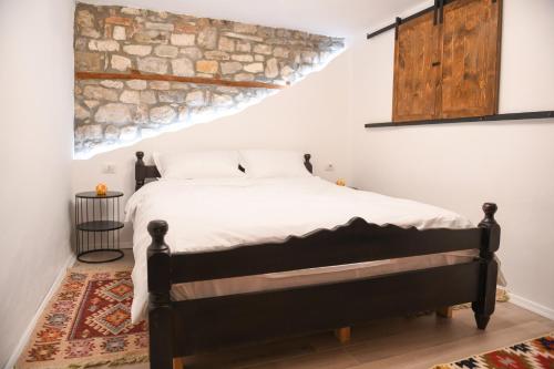 培拉特Villa Kokoshi, an extraordinary experience.的一间卧室配有一张石墙床