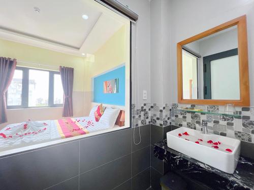 潘切Sea Star Hotel的一间带大镜子和盥洗盆的浴室