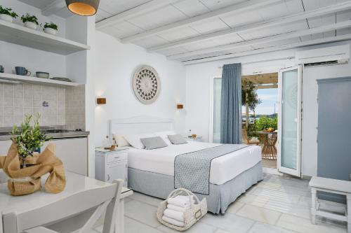 纳克索乔拉卡勒吉斯公寓酒店的一间白色卧室,配有床和阳台