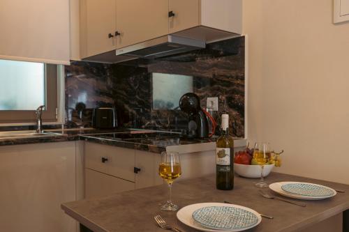 阿依亚埃夫菲亚Nicole Studios的厨房配有一张桌子和两杯葡萄酒