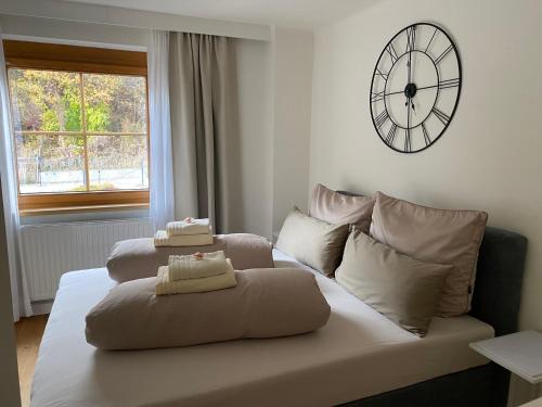 因斯布鲁克Gemütliche Wohnung mit Gartenblick的客厅的沙发,墙上有时钟