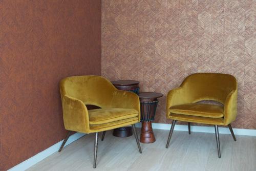 根特B&B Maaltebrug的两个黄色的椅子和一张桌子