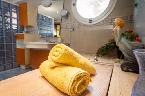 罗达德瓦拉HOTEL La Estrella del Mediterráneo的浴室柜台上方的黄毛巾