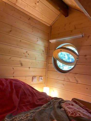 NatzwillerLe Paradis de Verdure的小木屋内一间卧室,设有圆形窗户
