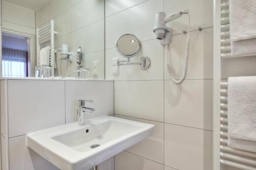 巴特恩多夫斯托宾格特蒙酒店的白色的浴室设有水槽和镜子