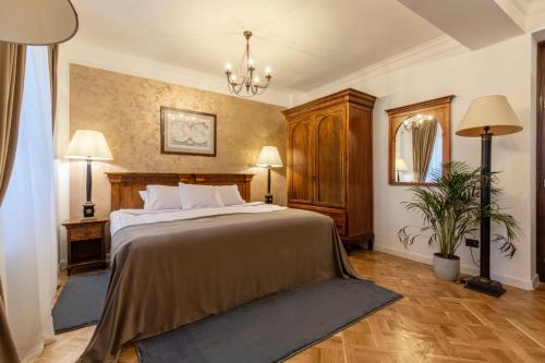 布加勒斯特Clucerului Arc De Triomphe的一间卧室配有一张大床和一个吊灯。