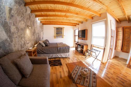 圣佩德罗·德·阿塔卡马Lodge Quelana的一间卧室配有一张床和一个沙发