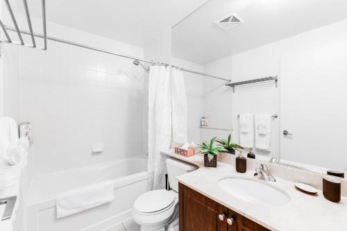 多伦多AOC Suites - High-Rise Condo - City View的白色的浴室设有水槽和卫生间。