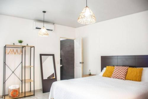 Habitacion Fuego - Villa Valle Campo的卧室配有一张白色大床和两个灯