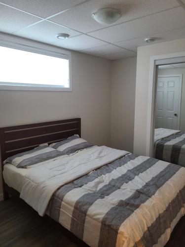 温尼伯Bethel Joyful Home的一间卧室设有两张床和窗户。