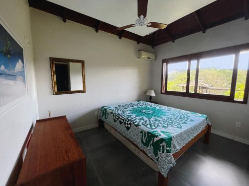 因比图巴Casa de praia no Rosa - vista para Lagoa de Ibiraquera的一间卧室设有一张床和一个窗口