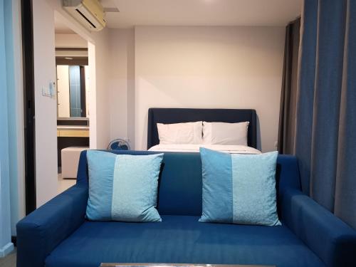 普吉镇4 Floor - Centrio Condominium near Shopping Malls and Andamanda Water Park的一张蓝色的沙发,床前配有两个枕头