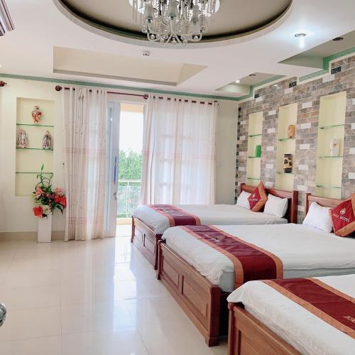 潘郎Khách Sạn FARA的一间卧室配有三张床和吊灯。