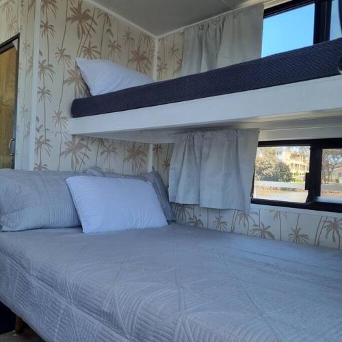 玛志洛The one & only Houseboat Hire on Maroochy River的宿舍间的一张床位,配有两张双层床