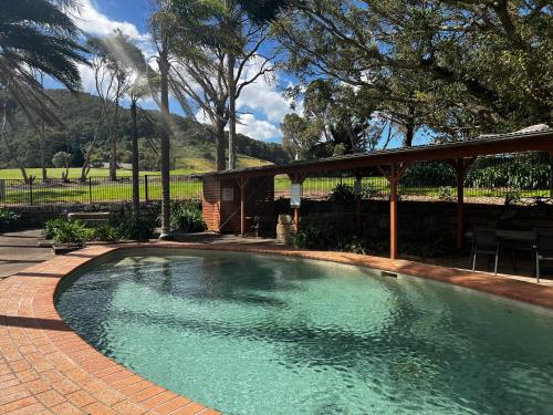 贝利Coolangatta Estate Shoalhaven Heads的一个带凉亭的庭院内的游泳池