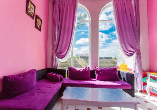 鹅銮鼻墾丁戀戀莎堡特色民宿 Castillo的紫色的客厅,配有紫色的沙发和窗户