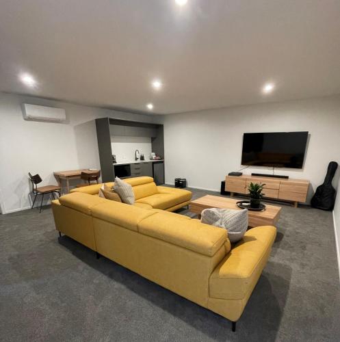 汉密尔顿Luxury at the Lake的客厅配有黄色沙发和平面电视。