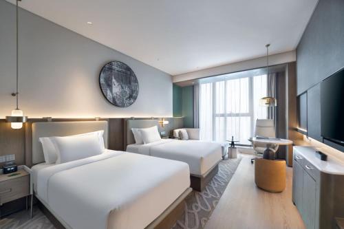 济南济南君瑞酒店的酒店客房设有两张床和一台平面电视。