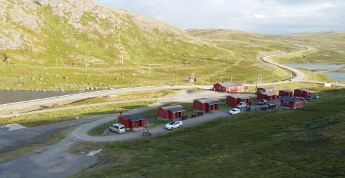 SkarsvågHytte Camp Nordkapp - Red的停在路边建筑物前面的一群汽车