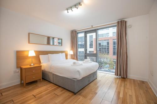 都柏林Parnell Corner Apartments的一间卧室设有一张床和一个大窗户