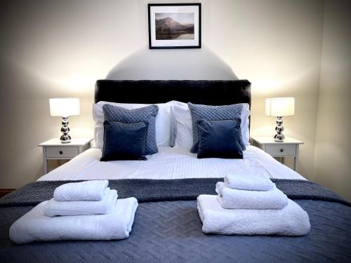 卢斯Lomond Castle Penthouse的一间卧室配有一张大床和毛巾