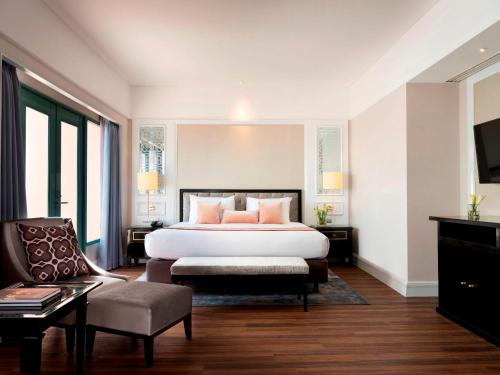 日惹Melia Purosani Yogyakarta的配有一张床和一把椅子的酒店客房
