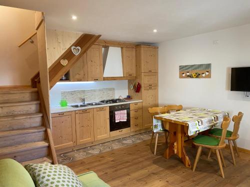 福尔加里亚Al Sole Mountain Chic的厨房以及带桌子和楼梯的用餐室。