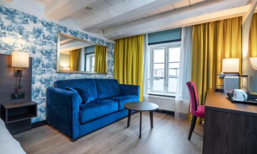 克里斯蒂安桑德索恩克里斯蒂安酒店的客厅配有蓝色的沙发和桌子
