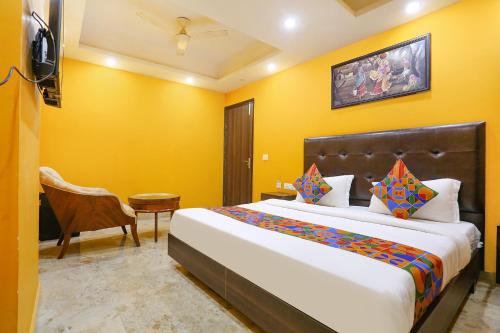 新德里FabExpress Taj Home Stay的一间卧室设有一张大床和黄色的墙壁