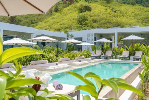 塞隆贝拉纳克Amazing Lombok Resort的一个带躺椅和遮阳伞的度假游泳池