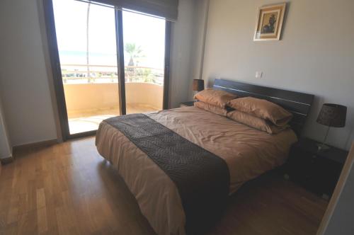 拉纳卡Ithaki Phinikoudes Apartment No. 201的一间卧室设有一张床,享有阳台的景色