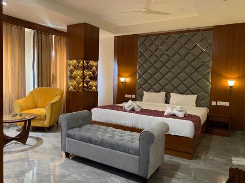 商沙巴海得拉巴格兰德酒店的一间卧室配有一张床、一张沙发和一把椅子