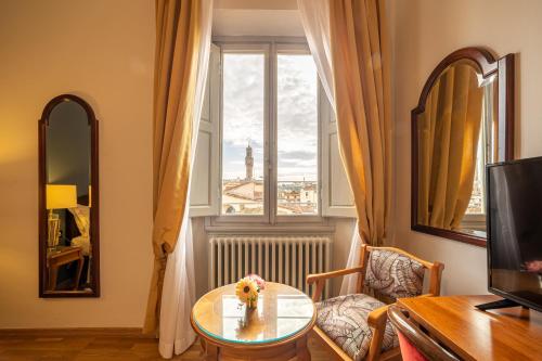 佛罗伦萨维拉尼酒店的客厅配有桌子和窗户