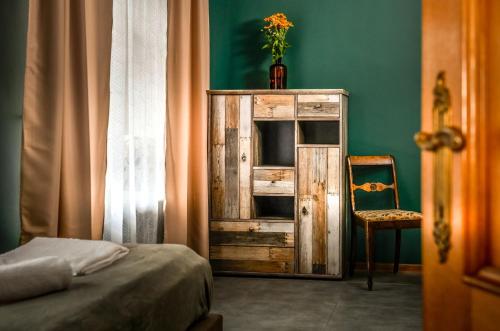 维德米内Dawna Apteka Old Pharmacy的一间卧室配有木制橱柜和椅子