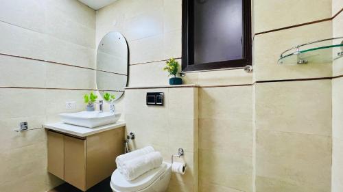 诺伊达Olive Service Apartments - City Centre Noida的一间带卫生间、水槽和镜子的浴室