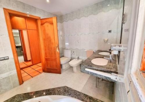 MarganellCasa Donaire, alojamiento turístico的浴室配有2个盥洗盆、卫生间和淋浴。