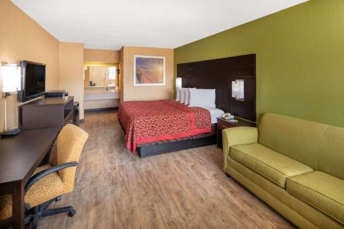 图珀洛图珀洛戴斯酒店的酒店客房配有一张床、一张书桌和沙发。